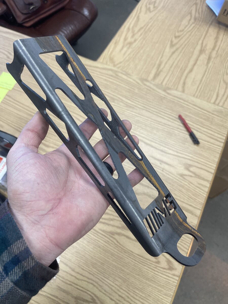 Laser-cut steel suspension link arm manufactured from SolidWorks CAD design at The High Road Manufacturing